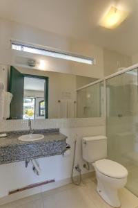 uma casa de banho com um WC, um lavatório e um espelho. em Pousada Abaeté em Florianópolis