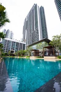 a large pool of blue water in front of tall buildings at Iskandar Residence by JBcity Home in Nusajaya