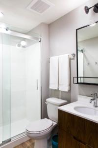 y baño con aseo, lavabo y ducha. en Uptown Suites Extended Stay Denver CO - Centennial, en Centennial