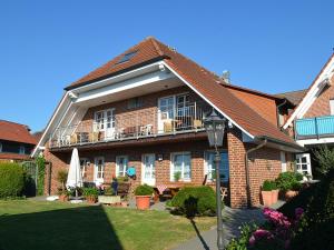 a brick house with a porch and a balcony at Hotel Gasthof Kruse in Nottuln