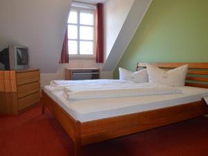 a bedroom with a large bed and a television at Hotel Gasthof Kruse in Nottuln