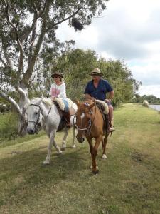a man and a woman riding on horses at Cabañas Maria Maria Conchillas in Conchillas