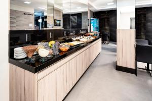 a buffet line with a lot of food on at Hotel Valerim Itajaí / Navegantes in Itajaí