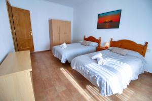a bedroom with two beds and a tv on the wall at CUENCALOFT EN SAN FELIPE in Cuenca