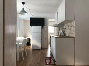 a kitchen with a refrigerator and a table with chairs at Calicanto Home in Passo del Tonale