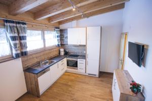 a small kitchen with white cabinets and a sink at Prünsterhof in Obertilliach