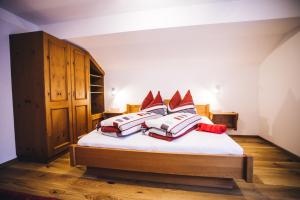 a bedroom with a bed with four pillows on it at Prünsterhof in Obertilliach