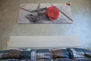 ベヴァーニャにあるAppartamento Della Piaのベッドルーム1室(ベッド1台付)が備わります。壁には絵画が飾られています。