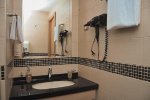 a bathroom with a sink and a phone on the wall at Apartman Mitra Angella Konaci in Kopaonik
