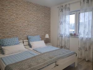 a bedroom with two beds and a brick wall at Appartement "Orchidee" in Hoya