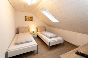 a attic bedroom with two beds and a skylight at Gästezimmer - Ferienwohnung 2 - Brauhaus Dürr in Dorfprozelten