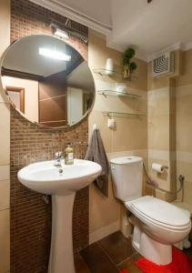 a bathroom with a sink and a toilet and a mirror at Socrates & Froso's lovely maisonette in Thessaloniki