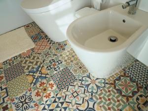 a bathroom with a toilet and a sink on a tile floor at Cantinho da Gândara in Arcos de Valdevez