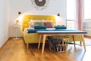 Una cama amarilla con una mesa en una habitación en Petite maison sur le boulevard en Bucarest