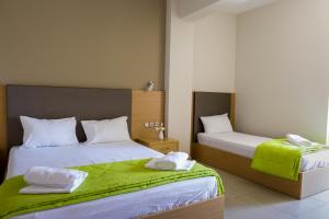 a bedroom with two beds with green sheets at Niriides Studios and Apartments in Paralia Katerinis