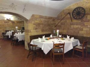 a dining room with white tables and chairs and a clock at Winzergarten Hotel-Restaurant in Großkarlbach