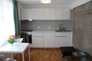 a kitchen with white cabinets and a white table at IW6 in Meersburg