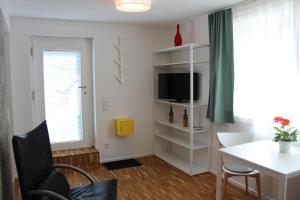 ein kleines Wohnzimmer mit einem Tisch und einem TV in der Unterkunft IW6 in Meersburg
