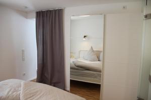 einen Spiegel in einem Zimmer mit einem Bett und einem Schlafzimmer in der Unterkunft IW6 in Meersburg