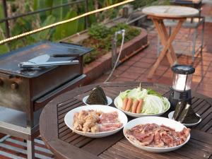 einen Tisch mit drei Teller Essen auf einem Grill in der Unterkunft Kunigami-gun - Hotel / Vacation STAY 11200 in Onna
