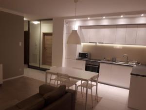 a kitchen and living room with a table and a couch at Wielicka Apartment 2 in Krakow