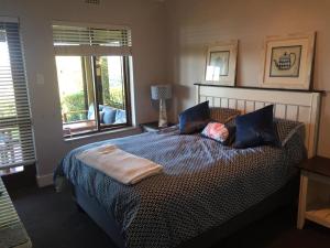 a bedroom with a bed with a person laying on it at 20A Castleton in Plettenberg Bay
