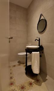 a bathroom with a sink and a toilet and a mirror at SANMARTINA HOTEL in Becerril de Campos