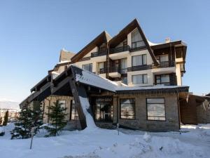 a large building with snow in front of it at F307 Studio Aspen Golf Resort Bansko in Bansko