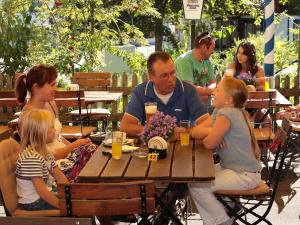 un grupo de personas sentadas en una mesa en un restaurante en Gasthof Rössle, en Rieden