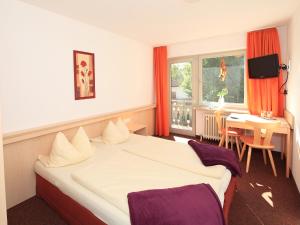 ein Hotelzimmer mit einem großen Bett und einem Tisch in der Unterkunft Gasthof Rössle in Rieden