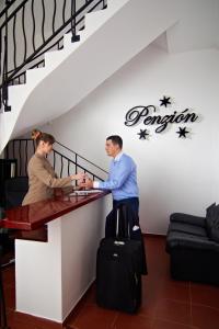 a man and woman standing at a table with luggage at Penzión Donet in Bratislava