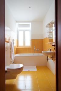 uma casa de banho com uma banheira, um WC e um lavatório. em Penzión Donet em Bratislava