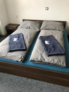 a bed with two blue pillows on it at Penzion malých pivovarů in Plzeň