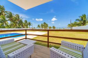 un balcón con 2 sillas y una piscina en Manga Verde Beach Residence en Itamaracá