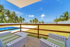 a balcony with two chairs and a swimming pool at Manga Verde Beach Residence in Itamaracá +213 photos