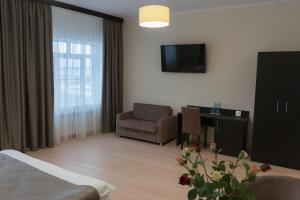 a hotel room with a bed and a chair and a television at Hotel Garazh in Syzran