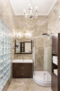 ein Bad mit einem Waschbecken, einer Dusche und einem Spiegel in der Unterkunft Hotel Baron in Odessa