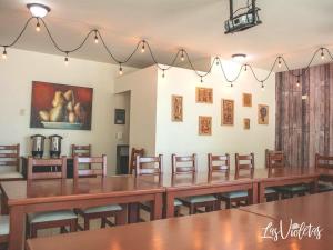 奧夫雷貢城的住宿－Gran Hotel Residencial Galerias，用餐室配有木桌和椅子