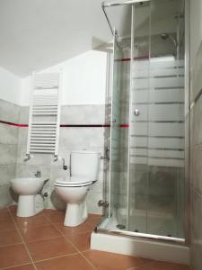 a bathroom with a toilet and a glass shower at Casa Arcobaleno in Siena +37 photos