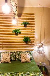 - une chambre dotée d'un lit avec 2 plantes en pot sur le mur dans l'établissement City Jungle, à Viterbe