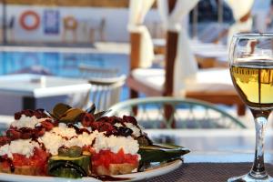 a plate of food and a glass of wine on a table at Ifestos Villa in Fira