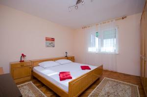 a bedroom with a bed with two red towels on it at Apartment Milan in Senj