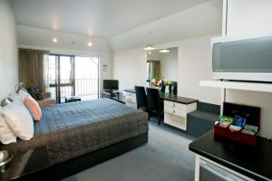 Dormitorio con cama, escritorio y TV en Cable Court Motel en Dunedin