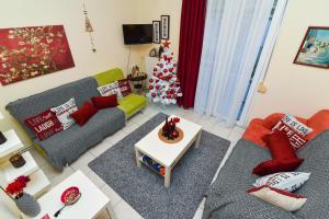 a living room with two couches and a christmas tree at Sissy’s House in Preveza
