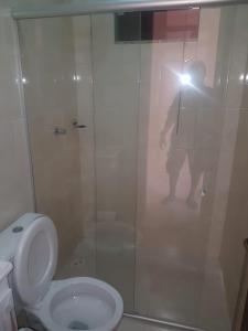 un homme prenant une photo d'une douche avec toilettes dans l'établissement Flat - Coroa Vermelha, à Santa Cruz Cabrália