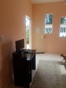 a desk with a computer and a dog in a room at Flat - Coroa Vermelha in Santa Cruz Cabrália
