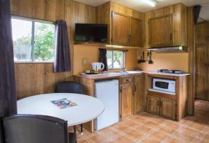 a small kitchen with a table and a white refrigerator at Warburton Holiday Park in Warburton