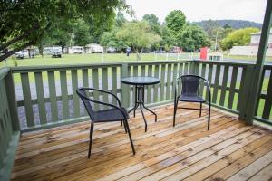 two chairs and a table on a wooden deck at Warburton Holiday Park in Warburton