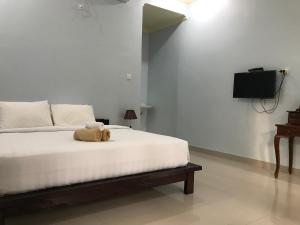 a teddy bear sitting on a bed in a bedroom at Bintang Hostel and Homestay in Nusa Penida