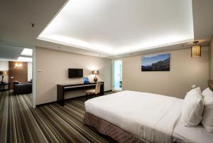 a hotel room with a bed and a desk at Yoyo Hotel in Chiayi City